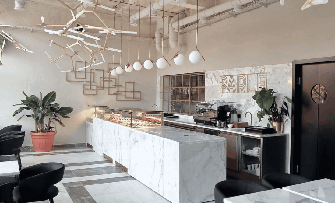 Parlé Patisserie – logotyp na ścianie nad ladą francuskiej piekarni