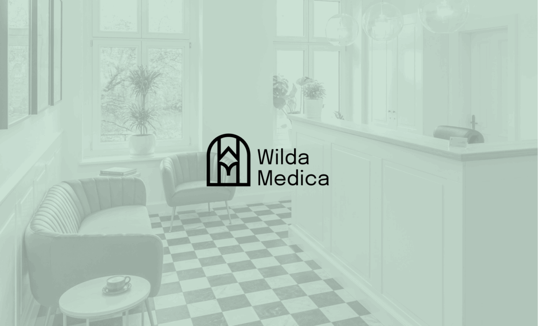Wilda Medica – logo kliniki na tle wnętrza recepcji