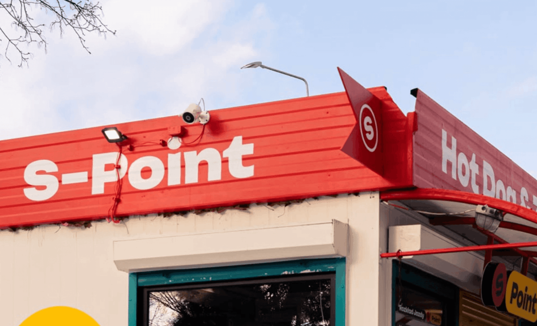 S-POINT – szyld z logo na czerwonej fasadzie kiosku